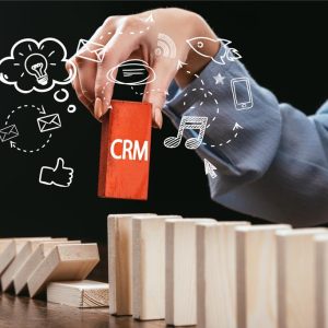 stock-photo-cropped-view-woman-picking-red-block-word-crm-out-wooden